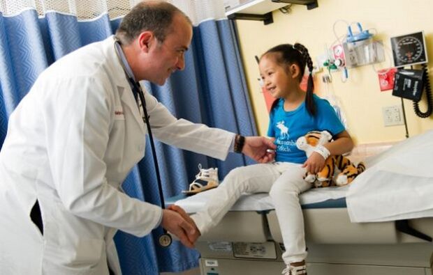 lekarz bada dziecko z artrozą stawu biodrowego